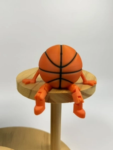 Macro detail of 3D printed basketball figure with movable joints on wooden base
