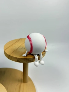 Macro shot of 3D printed baseball figurine with movable joints sitting on a wooden shelf