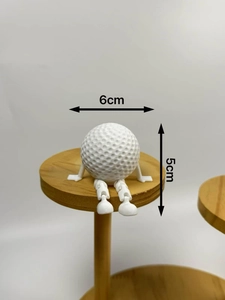 Creative white golf ball sitting figure ornament with movable joints on a wooden tray