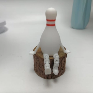 Articulated bowling pin figurine in sitting pose with movable limbs on wooden base