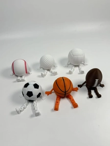 Detail view of 3D printed movable sports ball figurines in sitting poses on white background