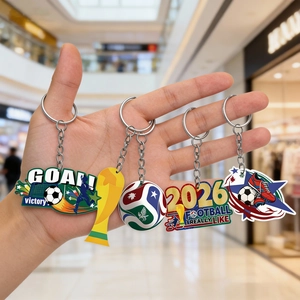 Detail shot of four football-themed acrylic keychains including 2026 and goal graphics