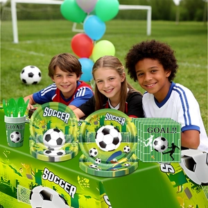 Soccer party tableware set on grass featuring plates, cups and soccer player napkins