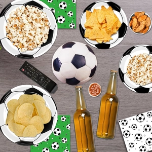 Close-up of soccer themed party paper plates and napkins on a dark wood texture table