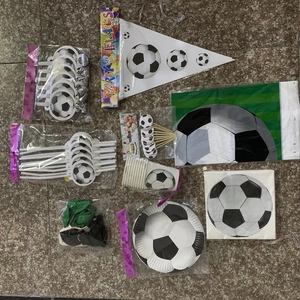Close-up of a soccer themed party set with flags, cake toppers, plates, and balloons