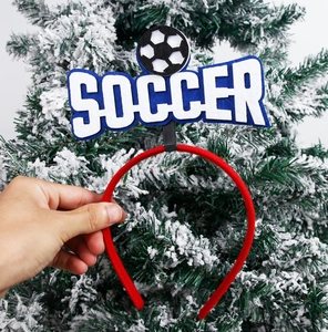 Detail of red soccer headband featuring white SOCCER text and a mini football ornament