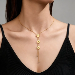 Gros plan d'un collier marguerite multicouche en acier doré avec pendentifs en cristal