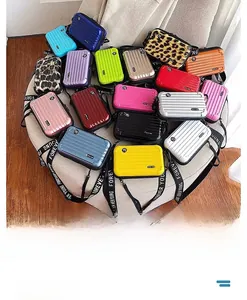 Assorted colors of hard shell mini suitcase crossbody bags with printed shoulder straps