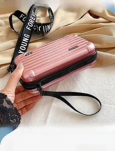 Detailed view of pink hard-shell mini suitcase bag with custom shoulder strap and FY logo
