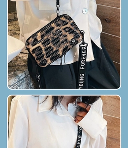 Detail view of leopard print mini hardshell crossbody bag with a wide lettered strap