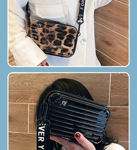 Detail of leopard print and glossy black hard shell mini suitcase crossbody bags