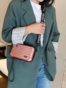 Mini rose gold hard shell crossbody bag with vertical grooves and printed strap
