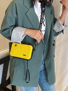 Bright yellow PC hard shell mini crossbody bag with grooved texture and black strap
