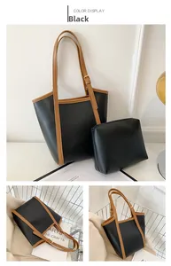 Detail view of large black tote bag with brown trim and matching zipper pouch set