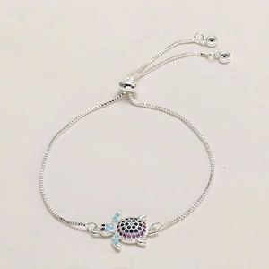 Macro detail of silver turtle bracelet featuring colorful pave-set zircon and adjustable clasp