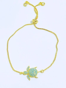 Detail of adjustable gold box chain bracelet with blue zircon sea turtle pendant