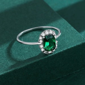 S925 silver ring featuring emerald cut gemstone and zircon halo on green pedestal