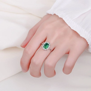 S925 sterling silver halo ring with oval emerald gemstone on a hand model