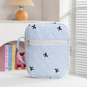 Light blue quilted book bag with floral embroidery and gold zipper closure