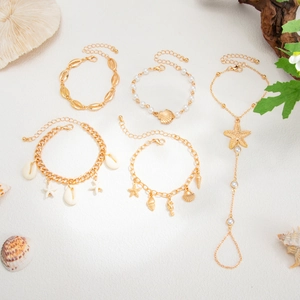 Makrofoto des 5-teiligen goldenen Strand-Schmucksets mit Muschel und Seestern
