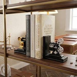 Vintage movie projector and camera bookends set on a wooden bookshelf for office decor
