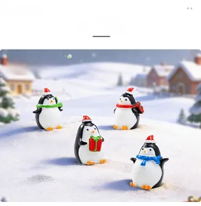 Miniature Christmas penguins with red hats and scarves on snow background