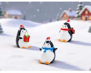 Three Christmas penguin miniatures in winter snow scene with festive holiday gifts