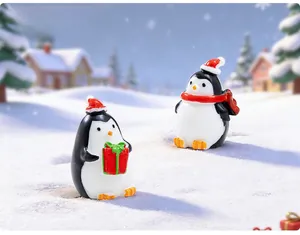 Detailed view of two miniature Christmas penguins with red hats and festive gift boxes
