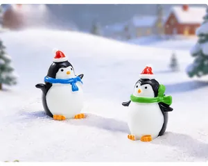 Miniature Christmas penguins with red hats and colorful scarves in a snowy winter scene