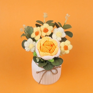 Mazzo di fiori all'uncinetto con rosa gialla e margherite in un vaso di ceramica bianca