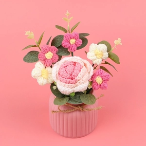 Bouquet di rose e margherite all'uncinetto fatte a mano in un vaso rosa rifinito