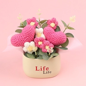 Planta en maceta de corazones rosas hechos a mano a ganchillo y flores en jarrón blanco