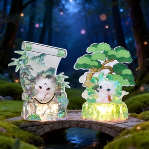 Detail of two resin fox figurines with glowing LED bases and landscape backdrops