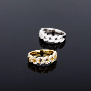 Macro shot of Cuban chain rings in gold and silver with shimmering paved zircon stones