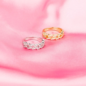 Macro shot of silver and gold Cuban link rings with pave zircons on pink silk