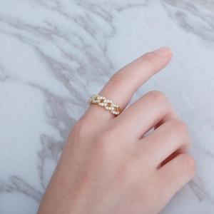 Close-up of a gold Cuban link ring with pavé-set cubic zirconia on a marble surface