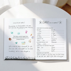 Neutral baby memory book for milestone tracking with cute illustrations on white table