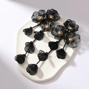 Detailed shot of long 3D black flower tassel earrings with crystals on stone base