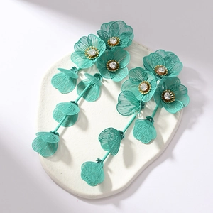 Detailed macro of mint green flower earrings with metallic mesh petals and crystal center