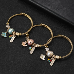 Three-piece gold twisted cable bracelets with floral enamel charms and beads
