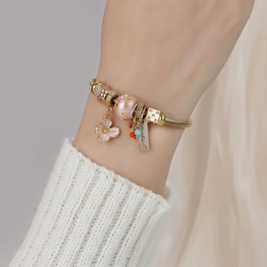 Gold stainless steel snake chain bracelet with pink flower charms and handmade tag