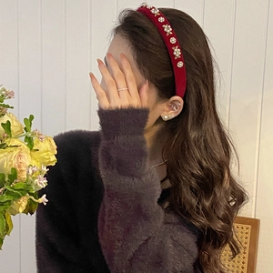 Detail of red velvet headband with white pearls and gold flowers on model