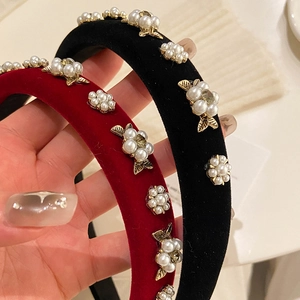 Close-up of luxury velvet flower headband featuring white pearls and gold metal leaves