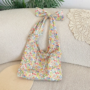 Detailed shot of floral canvas tote bag with large decorative bow and drawstring closure