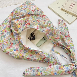 Detail of floral canvas tote bag showing interior space with phone and sunglasses
