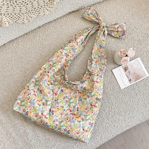 Floral canvas tote bag with decorative shoulder bow and drawstring closure detail