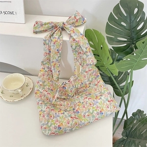 Detailed view of floral canvas tote bag with a large shoulder bow and tie closure