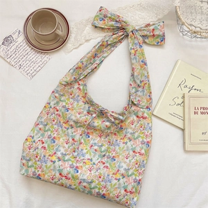 Close-up of floral tote bag showing delicate flower patterns and tied bow shoulder strap