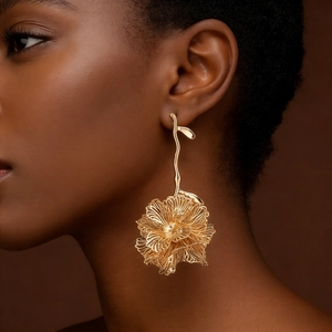 Luxurious gold layered flower drop earrings worn by a model against a dark background