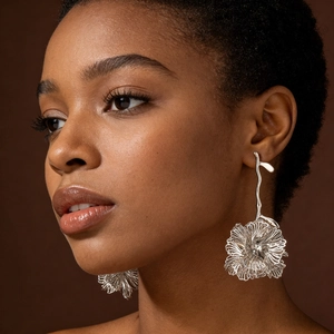 Artistic silver hollow floral drop earring with flowing lines on professional model